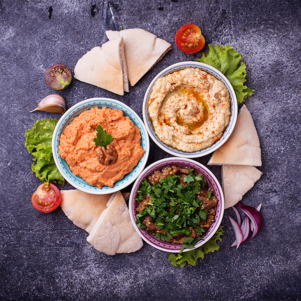 three dips of hummus, aubergine baba ganoush and red pepper muhammara